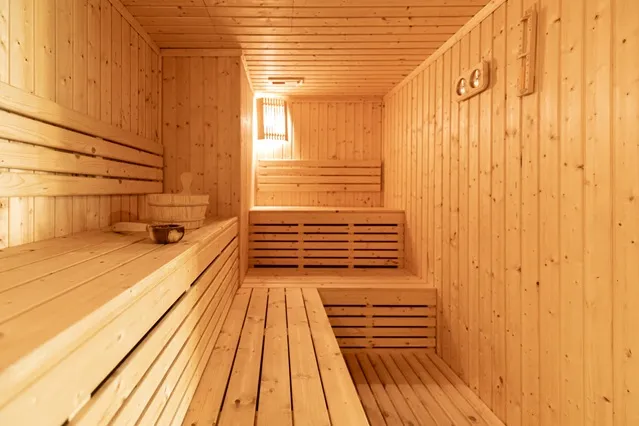 Helle Holzsauna mit sauberer Saunabank – Beispiel für richtiges Saunaholz reinigen und pflegen in der Heimsauna