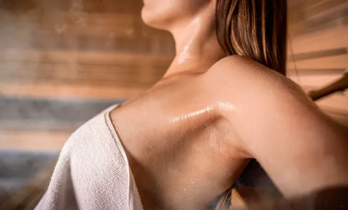 Frau beim Schwitzen in der Sauna zum Abnehmen
